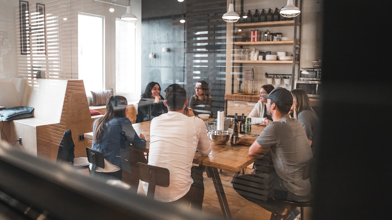 A small group of colleagues gathered around a table in a bright meeting room.