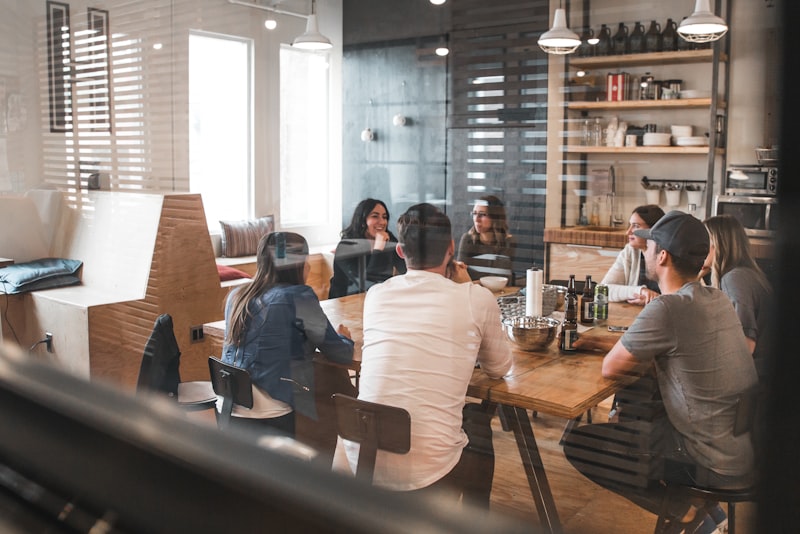 A small group of colleagues gathered around a table in a bright meeting room.
